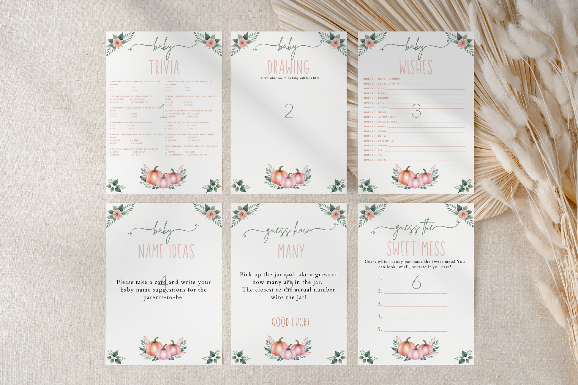 Set of baby shower game cards with floral designs on a textured surface.