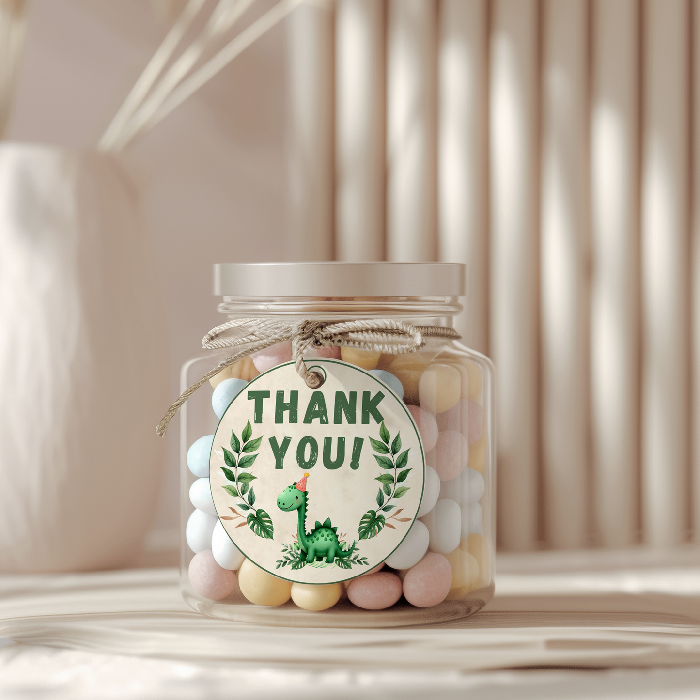 Jar of colorful candies with a 'Thank You!' tag featuring a dinosaur illustration on a neutral background.