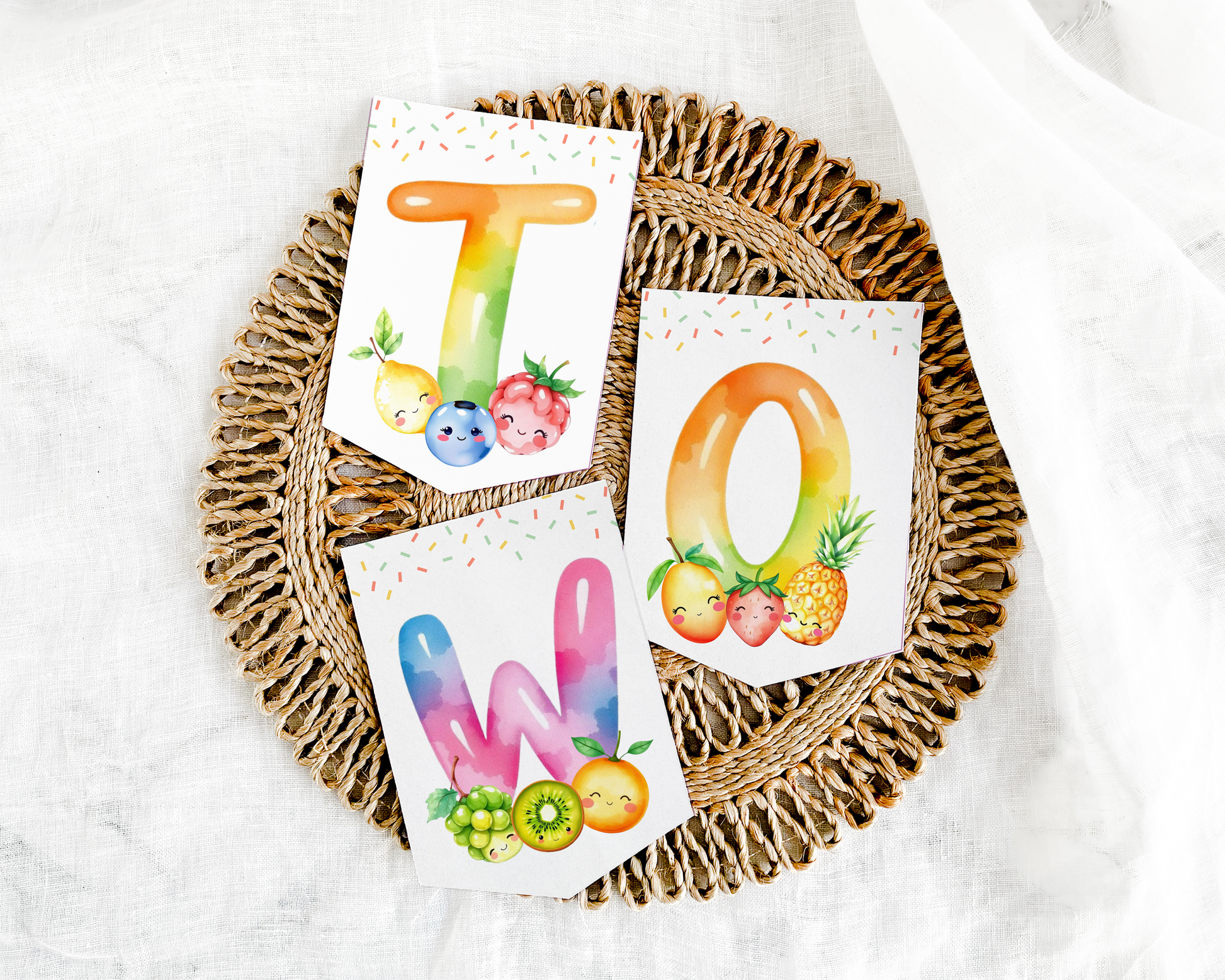 Three colorful alphabet cards with fruits on a woven tray
