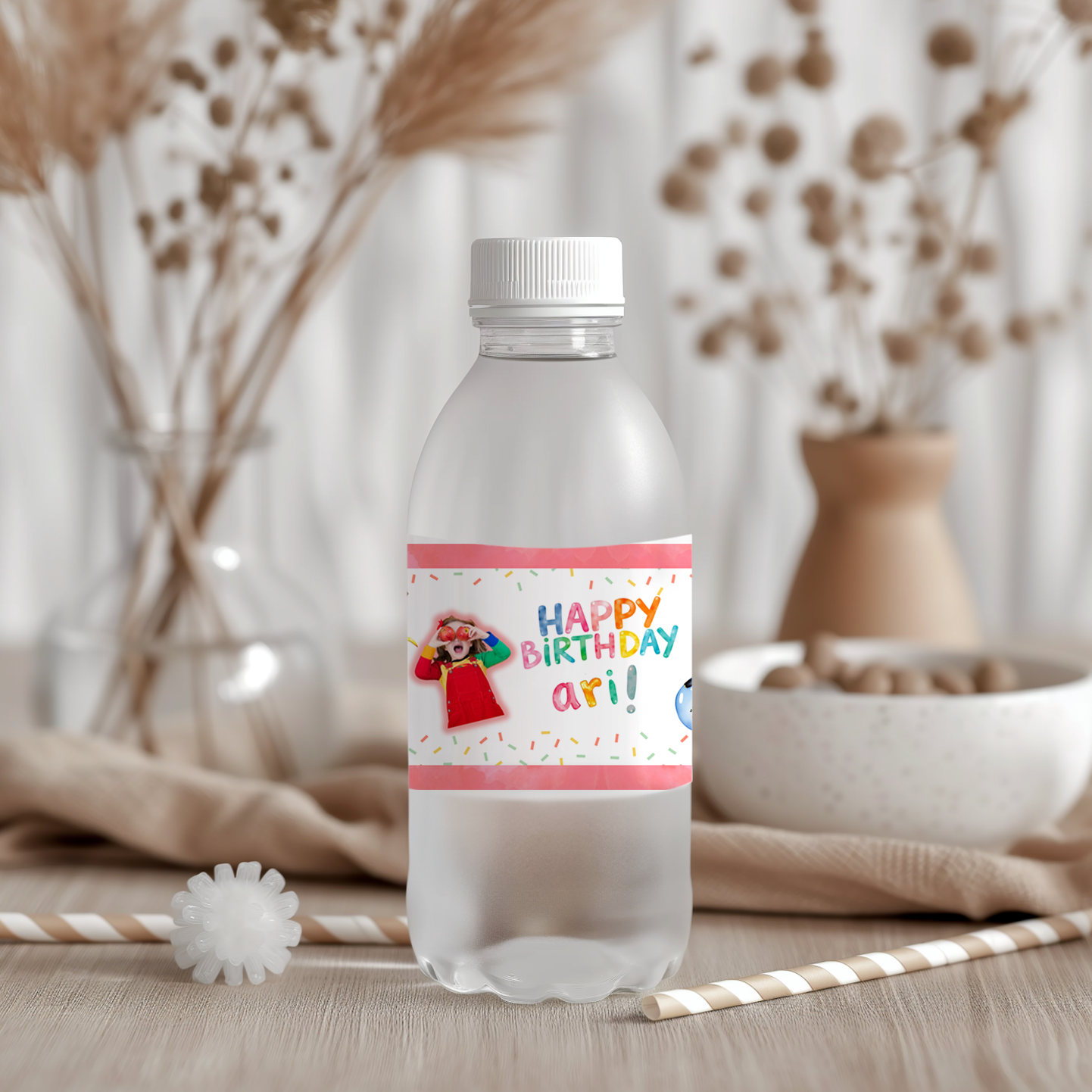 Plastic water bottle with a personalized birthday label on a neutral background