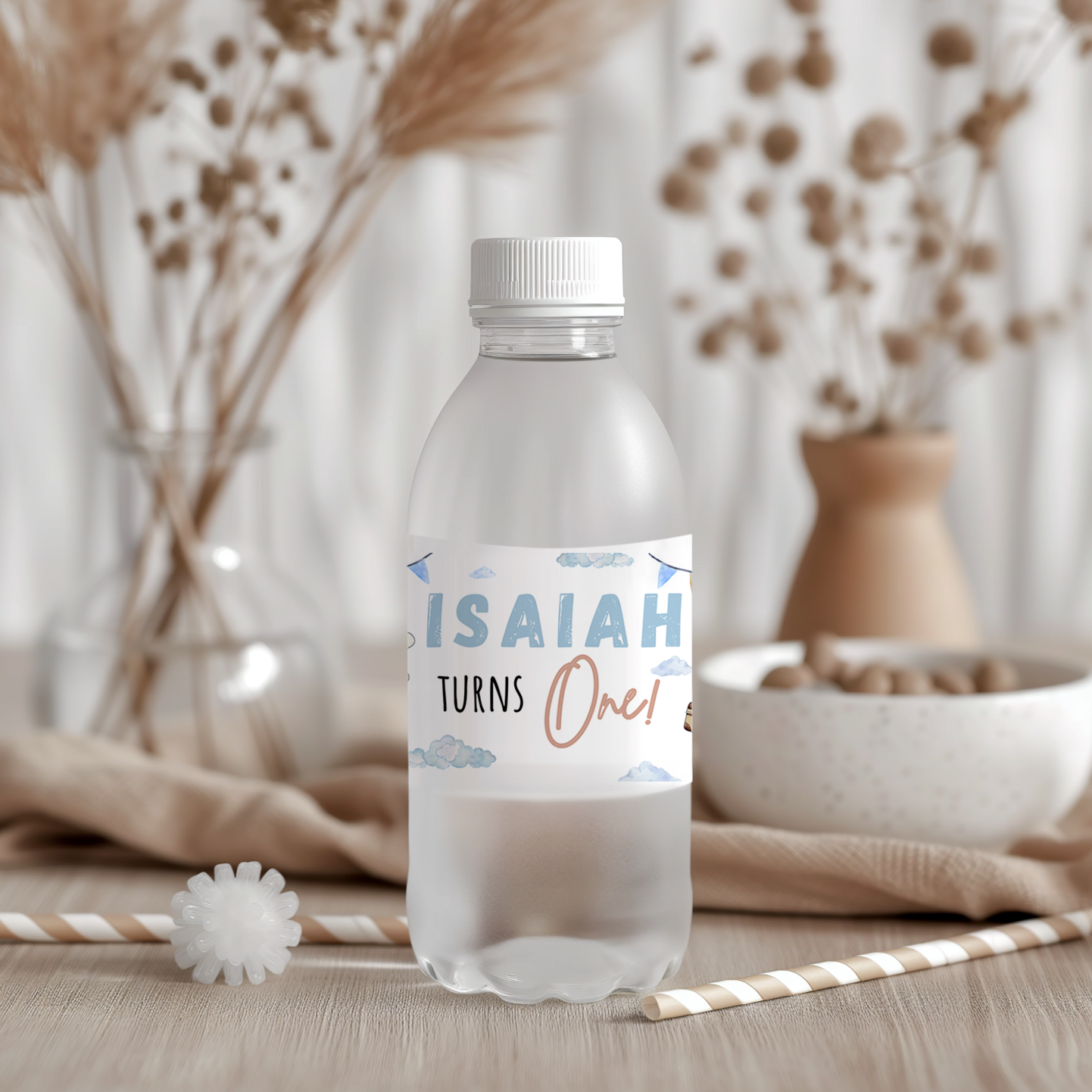 Plastic water bottle with a personalized label reading 'Isaiah Turns One' against a neutral background.