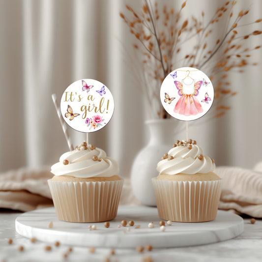Two cupcakes with decorative toppers on a marble surface with a neutral background