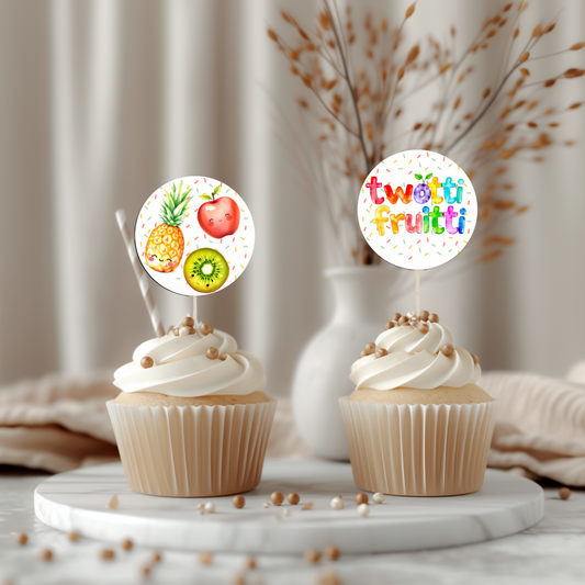 Two cupcakes with fruit-themed toppers on a marble surface with a neutral background