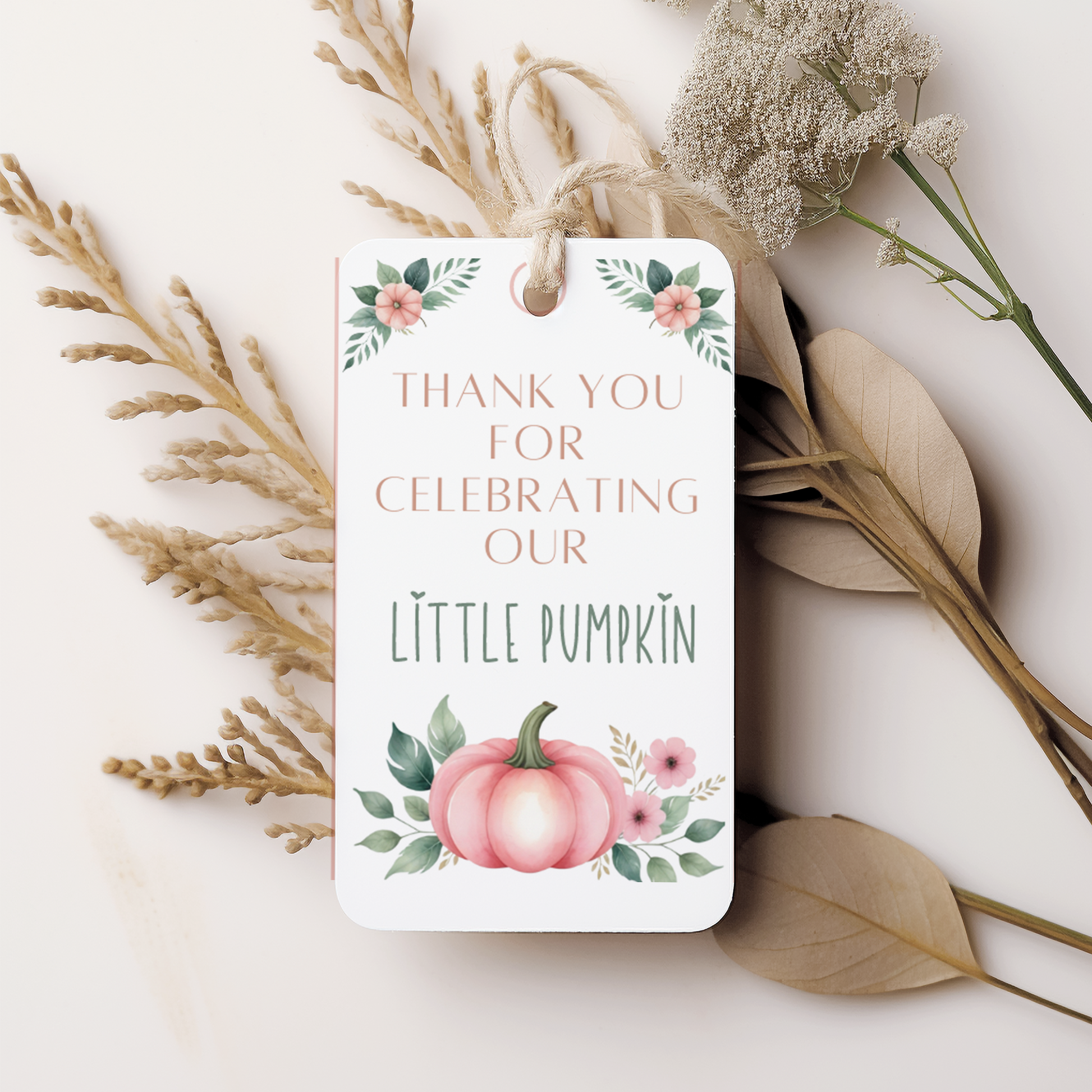 Gift tag with 'Thank you for celebrating our little pumpkin' text and pumpkin illustration on a white background with dried plants.