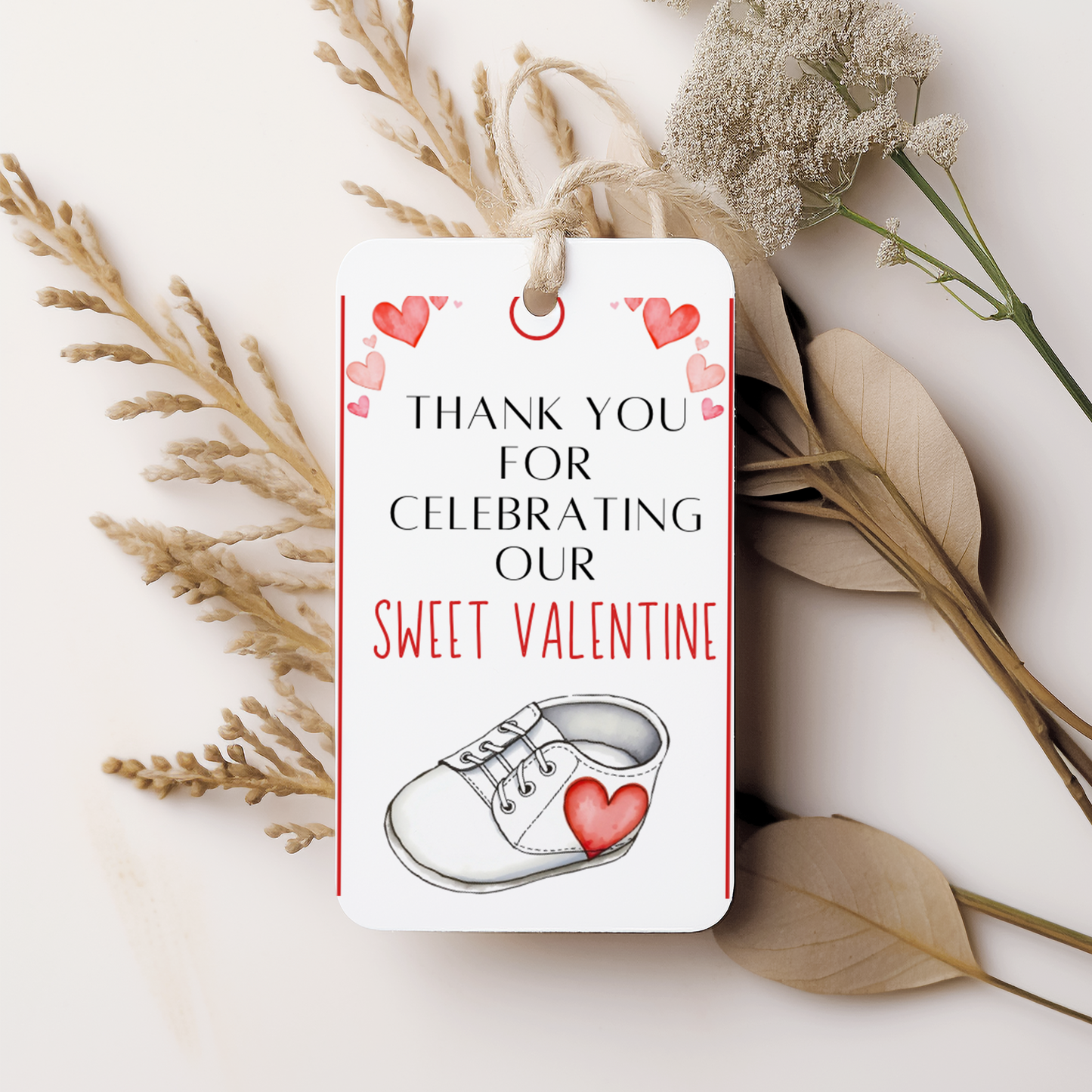 Gift tag with Valentine's Day message and shoe illustration on a white background with dried plants.