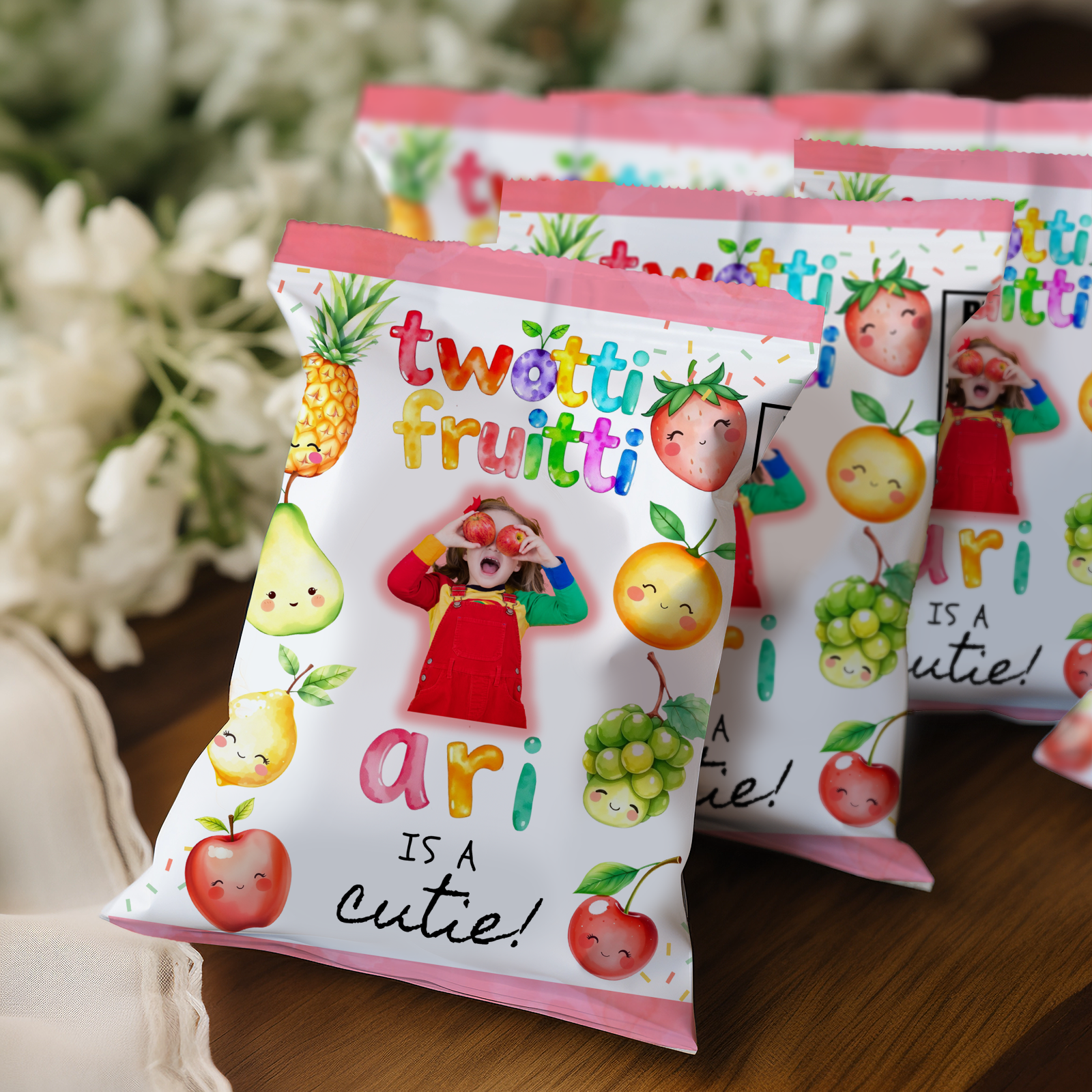 Packets of 'twotti fruitti' with cartoon fruits and text on a wooden surface.
