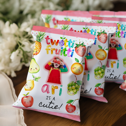 Packets of 'twotti fruitti' with cartoon fruits and text on a wooden surface.