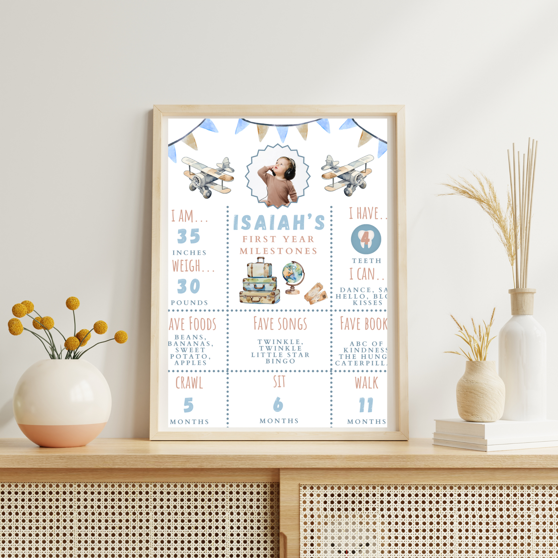 Framed baby milestone chart on a shelf with decorative items