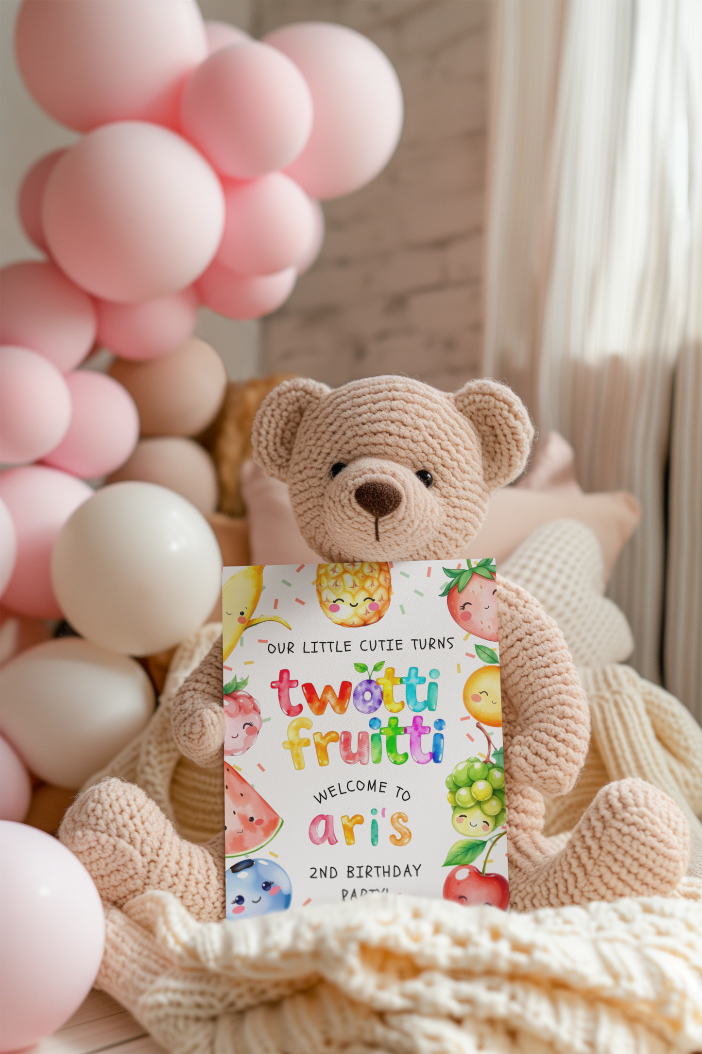 Teddy bear holding a birthday card with balloons in the background