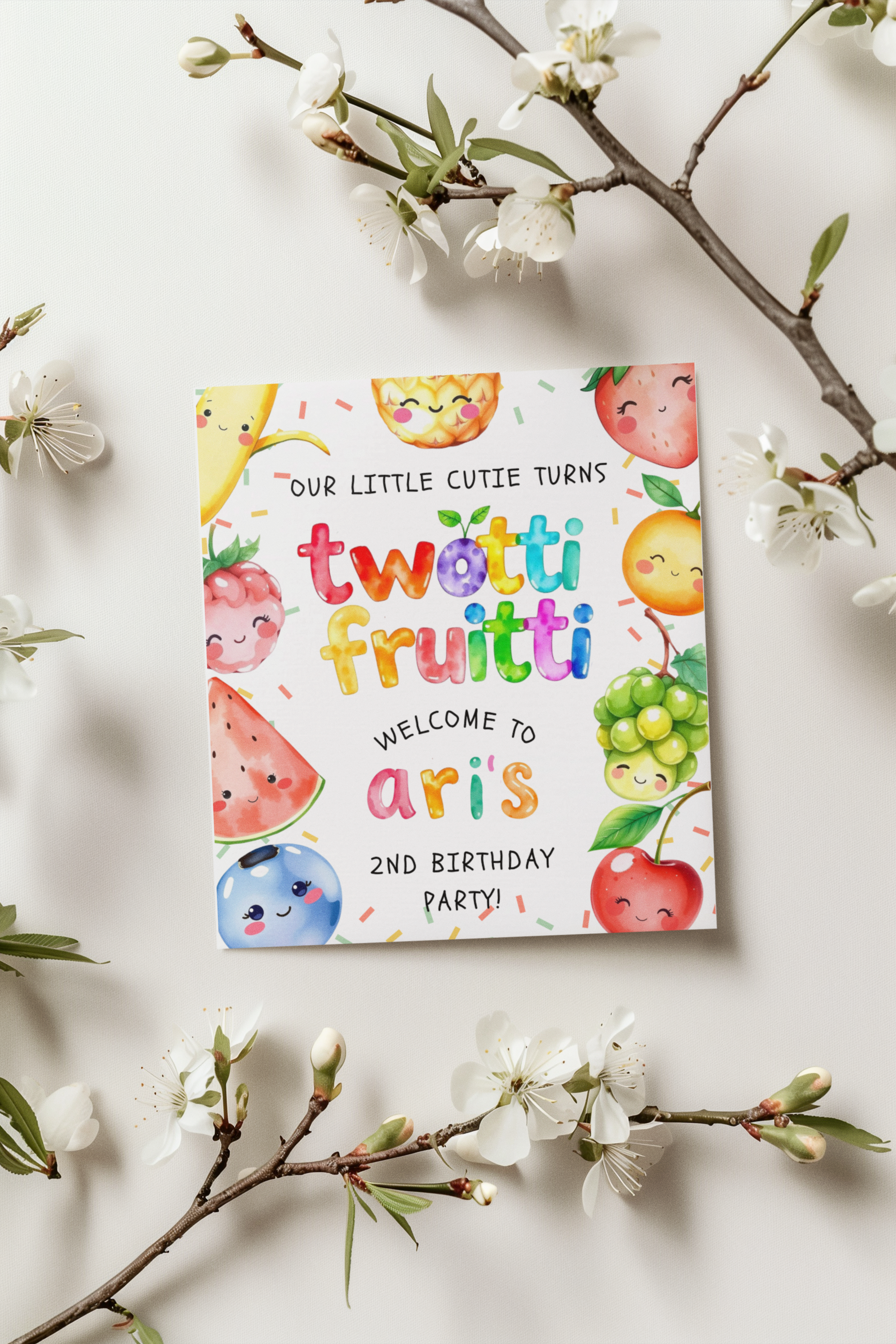 Colorful birthday invitation card with fruit illustrations on a white background with floral branches.
