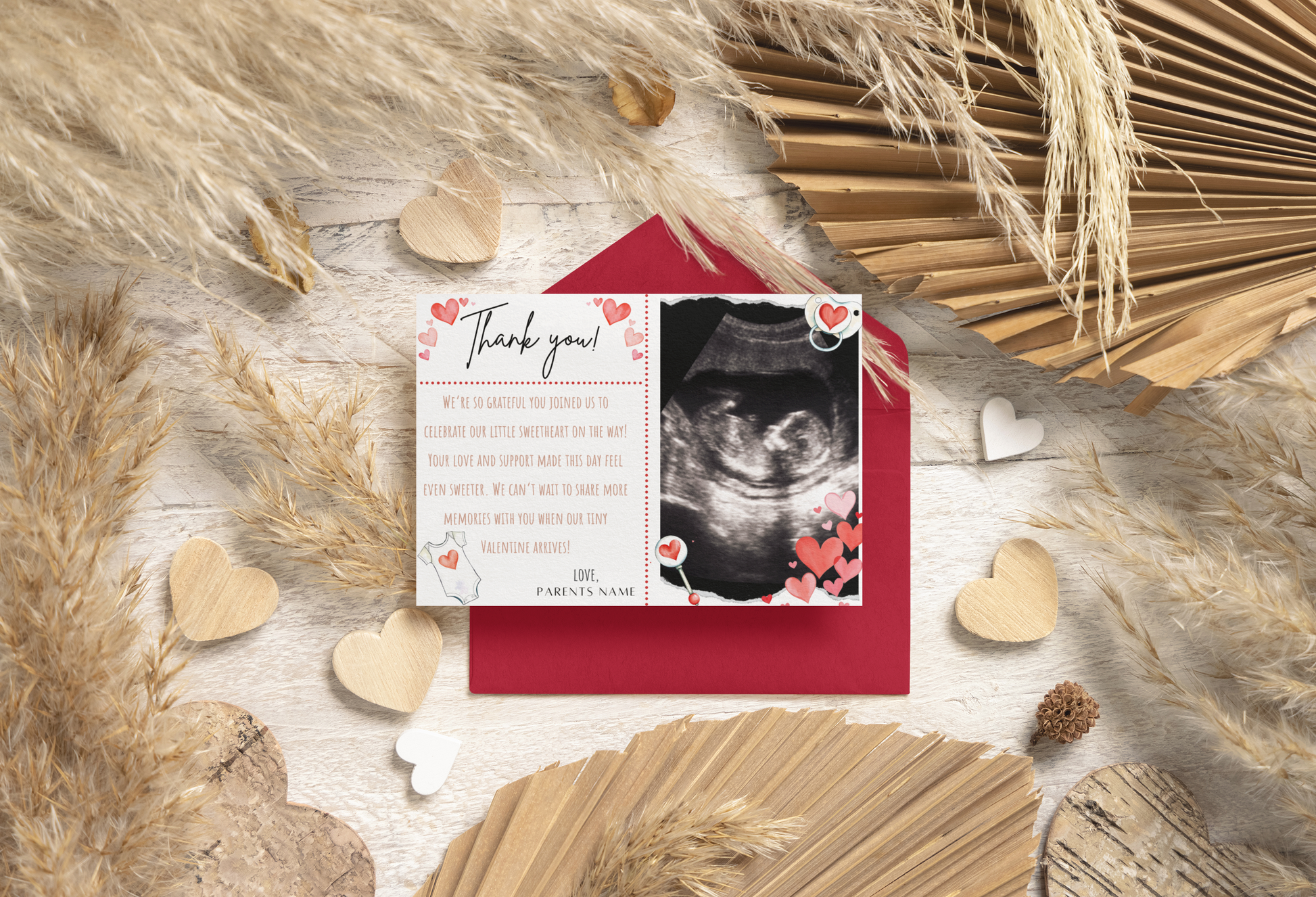 Thank you card with ultrasound photo surrounded by decorative elements on a wooden surface