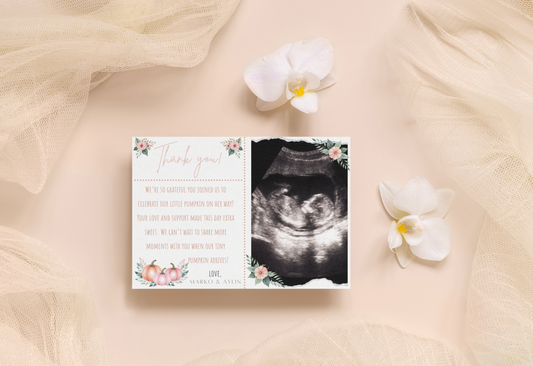 Baby shower invitation with ultrasound photo and floral design on a soft fabric background