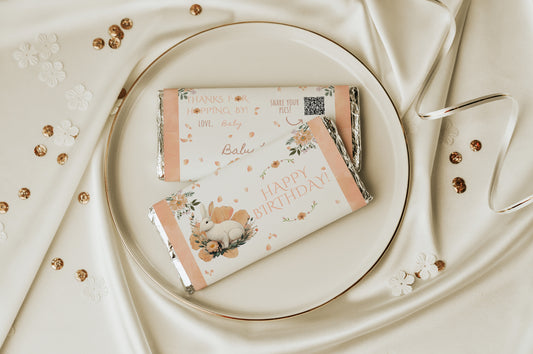 Two floral-themed chocolate bars on a white plate with a decorative background