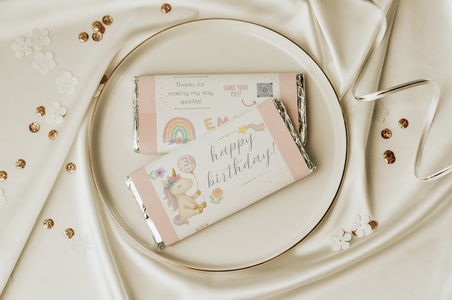 Two small gift boxes with decorative packaging on a white plate with gold accents.