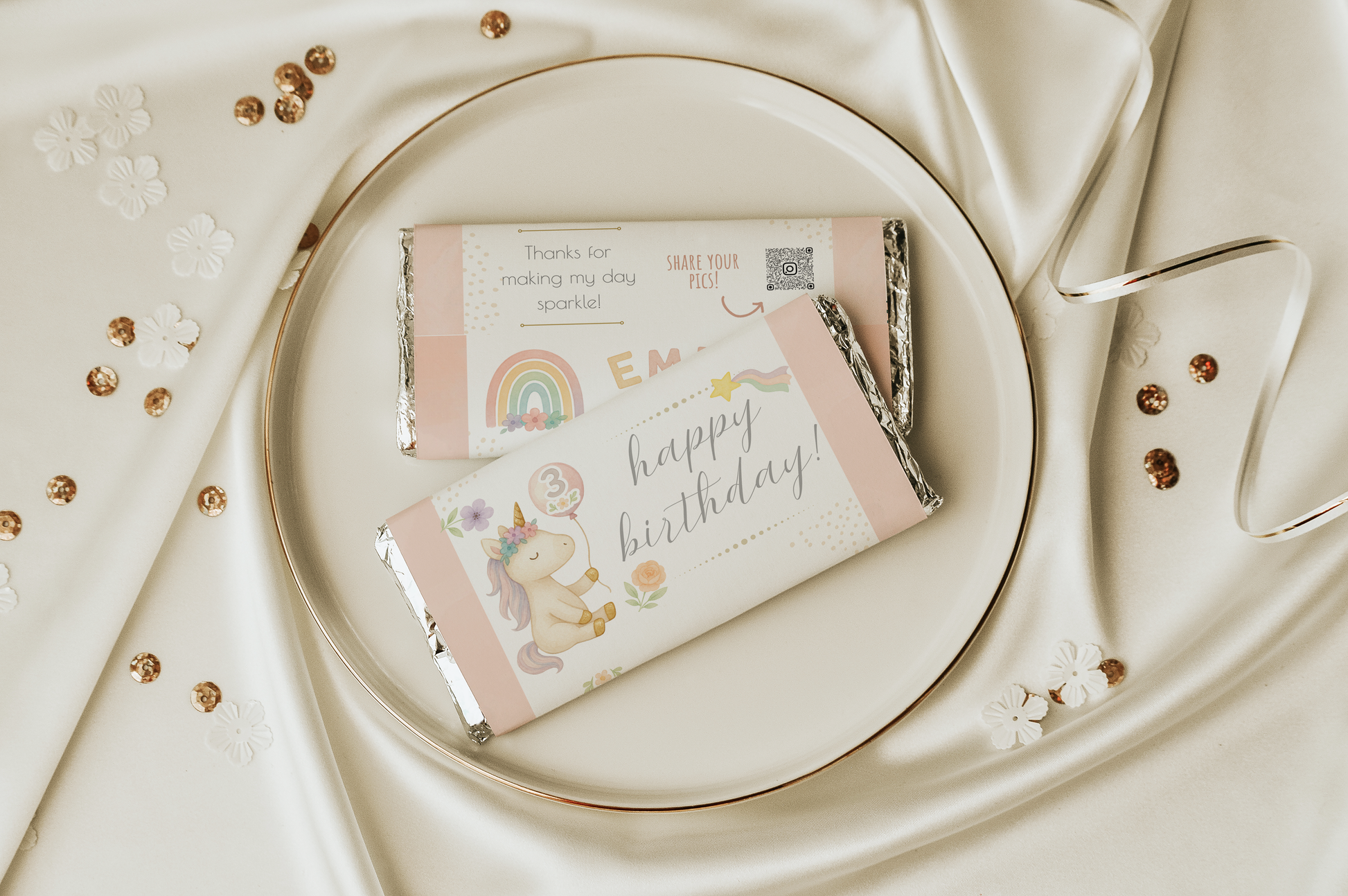 Two small gift boxes with decorative packaging on a white plate with gold accents.