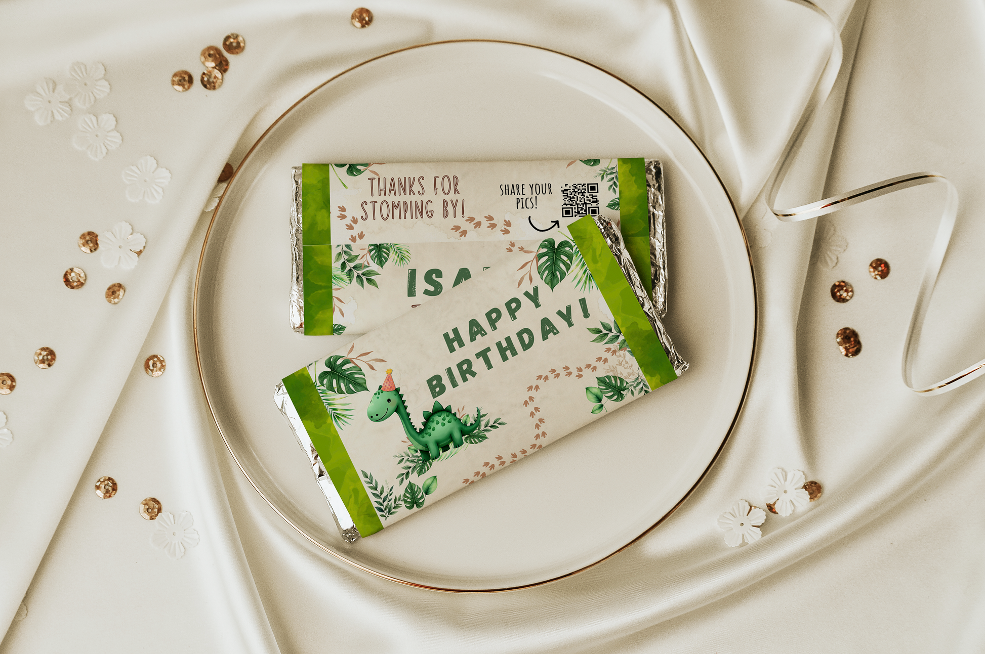 Two green chocolate bars with dinosaur illustrations on a white plate.