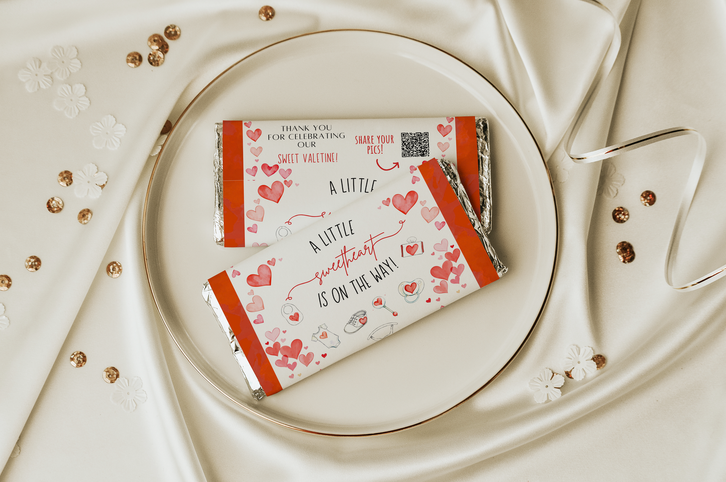 Two chocolate bars with Valentine's Day-themed packaging on a white plate with a decorative background.
